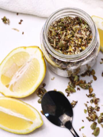 jar of granola with lemon wedges on the counter