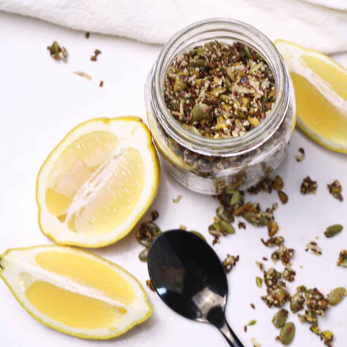 jar of granola with lemon wedges on the counter