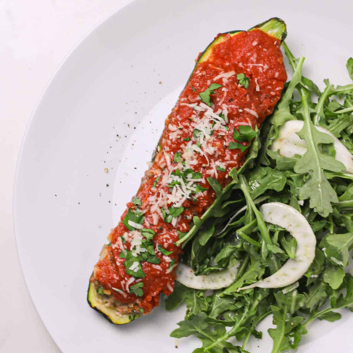 stuffed zucchini and arugula salad on a plate